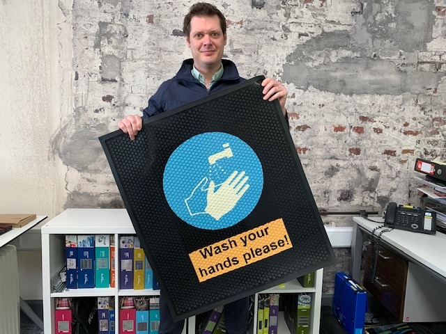 Richard Mayne of Footfall displaying a new rubber hand wash message mat
